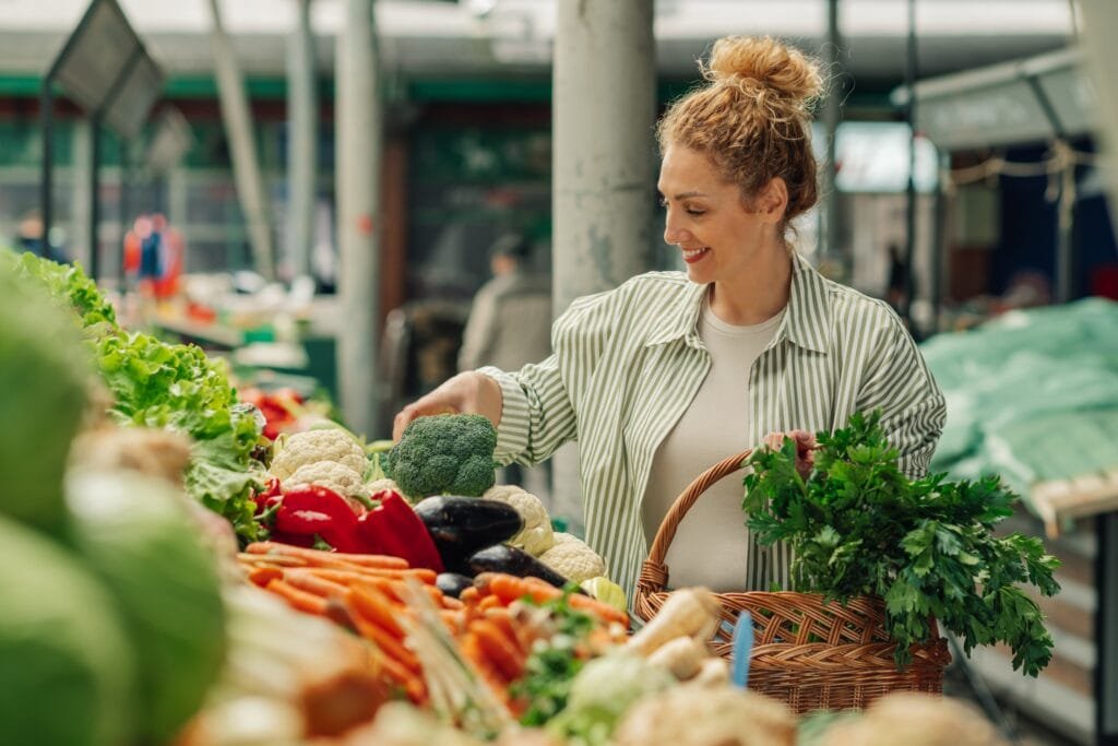 portrait,of,a,smiling,female,shopper,standing,near,market,stall